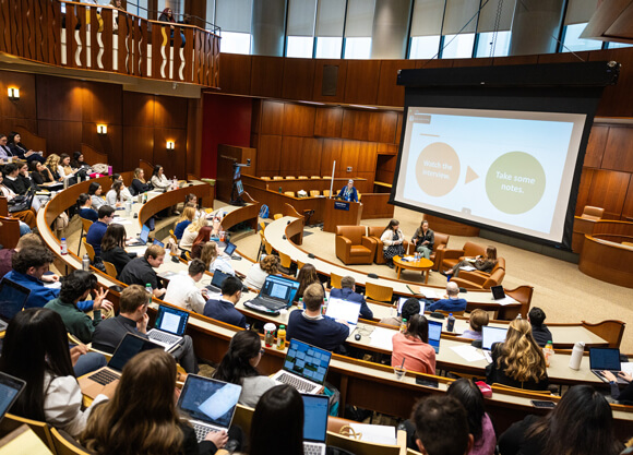 Individuals sitting in the law auditorium