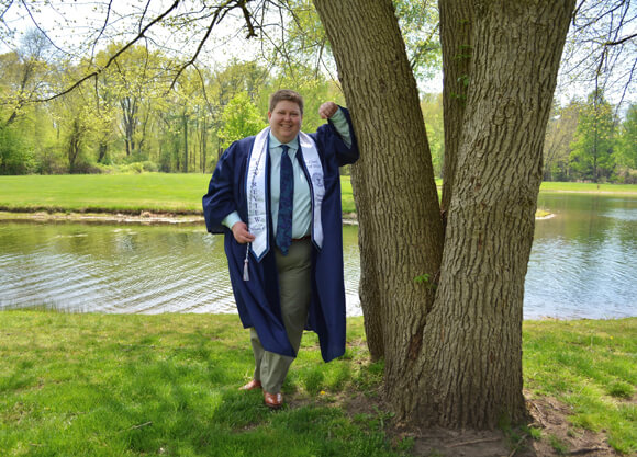 Andie King poses next to a tree