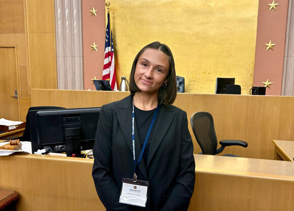 Photo of a Quinnipiac Law student standing in a courtroom.