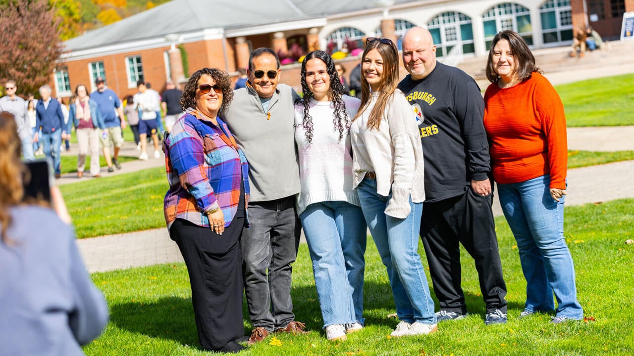 Families and students pose together for a photo on the quad
