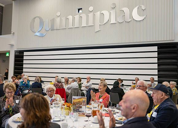 Larson and Quinnipiac alumni attend the heritage luncheon.