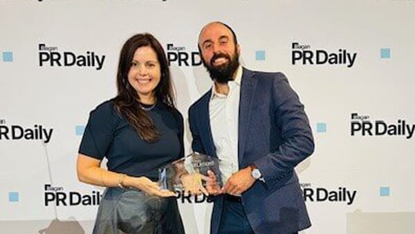 Ben Teicher poses with his award and another person from PR Daily