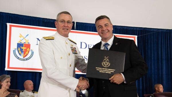 Jeremiah	Cottle in his military uniform receiving his diploma from National Defense University